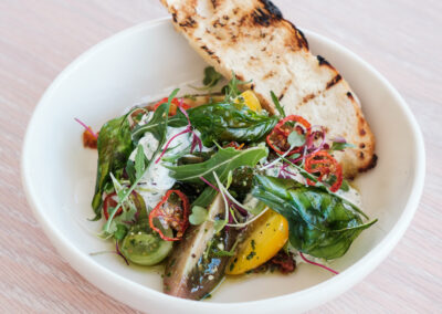 tashas LXX - Tomato Caprese - heirloom tomatoes, basil dressing, herbed stracciatella, cherry tomato chips, rocket, crispy basil, micro herbs & charred ciabatta